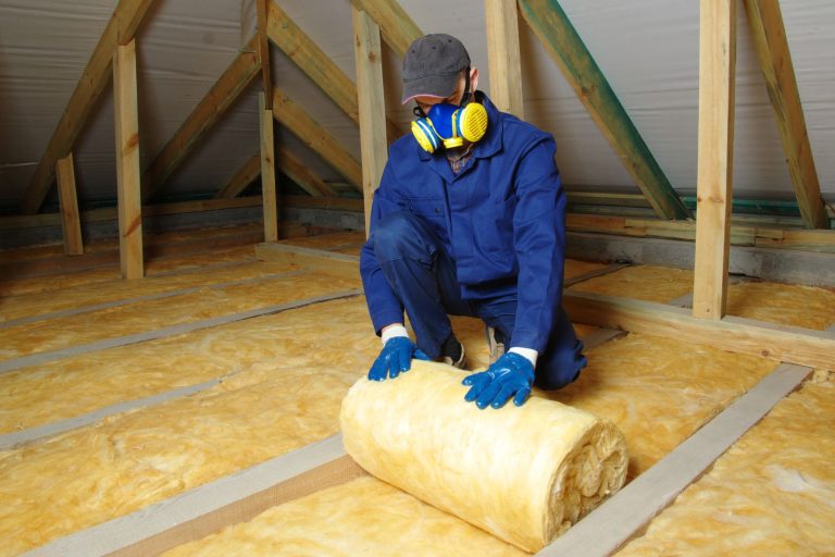 Man,Installing,Thermal,Insulation,Layer,Under,The,Roof,,Using,Mineral